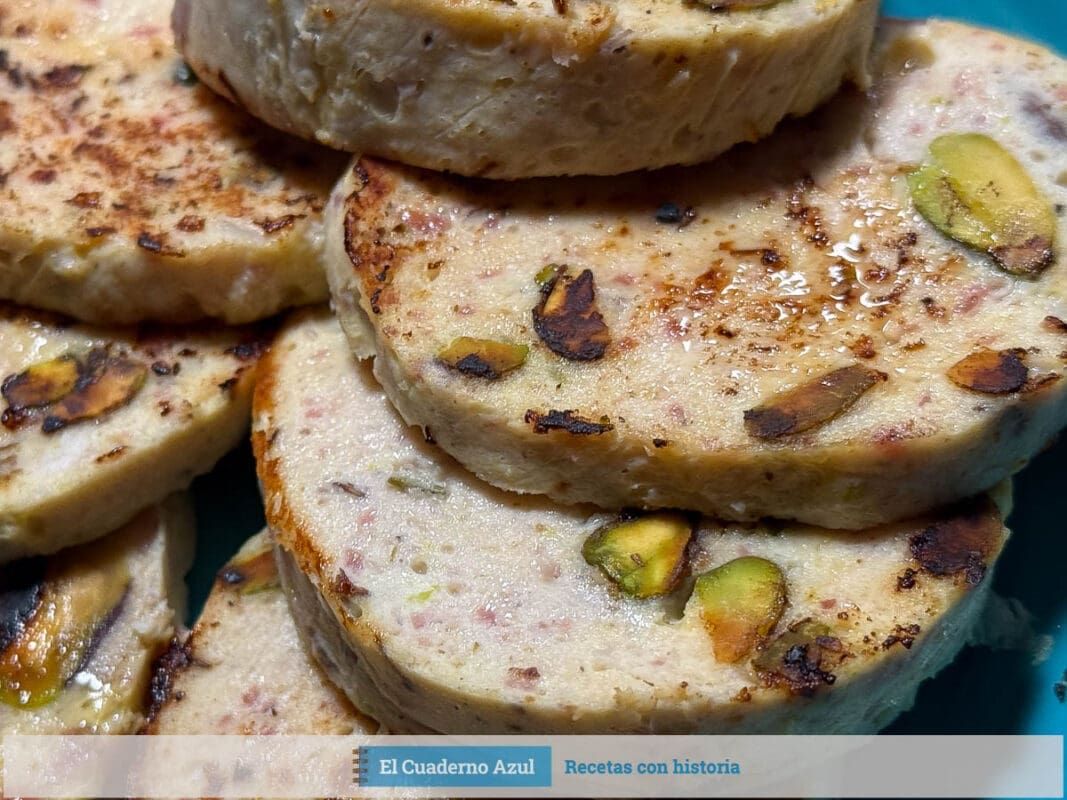 fiambre de pollo con pistachos cortado en medallones sobre plato azul