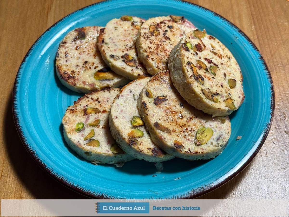 fiambre de pollo con pistachos cortado en medallones sobre plato azul